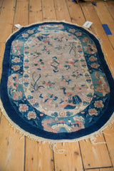 Curvilinear Art Deco rug with cobalt blue border and dusty blush peacock.