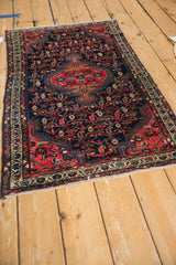 Vintage Tajabad rug corner showing faded cherry red finned medallion contour on navy field.