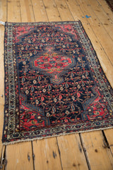 Detail of the vintage Tajabad rug's scrolling vinery, boteh motifs, and intricate patterned border.