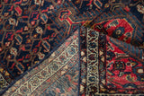 Vintage Tajabad rug corner showing hand-knotted navy and red vinery, selvage, and woven reverse.