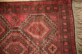 Vintage Belouch rug, raspberry red guls, serrated edges, coffee brown border, and natural fringe.