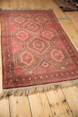 Vintage Belouch rug corner showing natural fringe, serrated serpent border, and geometric guls.