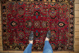 Vintage Sarouk rug with cherry red field, sapphire palmettes, and serrated blossoms.
