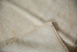 Hand-knotted foundation and distressed ivory pile texture of the vintage Melas rug.