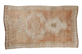 Vintage distressed Oushak rug with an asymmetric medallion, abrashed copper blush, and wide wave border.