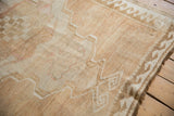 Wide reciprocating wave main border and fringed edge on a distressed Oushak rug.