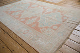 Faded cantaloup melon and dusty mint medallions on a distressed vintage Oushak rug.