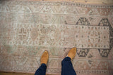 Distressed Melas runner detail showing worn pile and geometric patterns in muted colors.