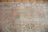 Distressed Melas rug pile with mostly even wear, highlighting soft beige and pale pinks.