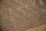 Vintage Bokhara runner's distressed beige pile, subtle pink border, and secure selvage.