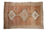 Vintage distressed Oushak carpet featuring three serrated medallions and an abrashed field.