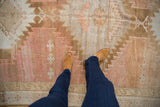 Distressed vintage Oushak rug with abrash, showing serrated patterns and pale blush tones.