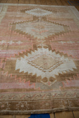 Distressed vintage Oushak rug, showing abrashed field and serrated pattern in apricot, blush, and sand.