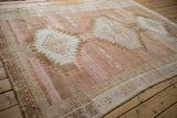 Distressed Oushak carpet showing abrashed field, serrated medallion, and apricot pink hues.