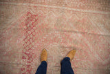 Distressed vintage Shiraz carpet with worn blush pink and beige floral diamond patterns.