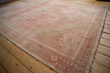 Distressed blush and beige vintage Shiraz rug showing geometric blossoms and hook and latch medallion.