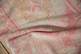 Faded geometric floral motifs and distressed pile of a vintage Oushak rug runner.