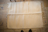 Textured natural undyed organic cotton rag rug with visible central fold.