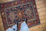 Vintage Karaja rug with geometric navy field and cherry red arabesque floral leaf border.