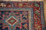 Vintage Karaja rug corner with geometric field and arabesque border in navy and red.