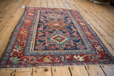 Close-up of vintage Karaja rug's expressive cherry red arabesque border and navy field.