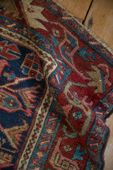 Intricate arabesque and floral leaf main border of the Karaja rug, rich in navy, red, and teal.