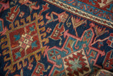 Textured pile of Vintage Karaja rug showing navy, cherry red, and teal geometric motifs.