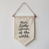 Handmade natural cotton banner with black script 'our little corner of the world', 8.5x16 inches.