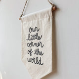 Top right detail of the natural unbleached cotton banner with wooden dowel and twine.
