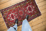 Showing the scale of a fine vintage Karaja rug with red and navy geometric patterns.