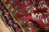 Angled view of a Karaja rug's rich red pile, navy border, and woven side cord.