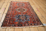 Corner view of a vintage Karaja rug showing the starburst motif border and intact side cord.
