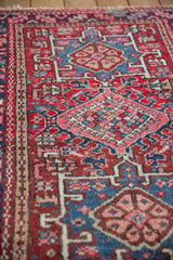 Geometric patterned vintage Karaja rug showing checkered medallion, brick red, navy, and blush pile.