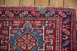 Vintage Karaja rug corner detail, showing red, navy geometric patterns and knot heads.