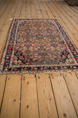 Tattered fringe and navy blue blossom border of the vintage Hamadan rug.