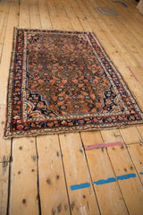 Corner of vintage Hamadan rug featuring tattered fringe and worn knot heads.