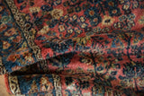 Folded vintage Lilihan rug pile with dense, plush texture and raspberry, sapphire, beige florals.