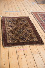 Angled view of a vintage Belouch rug showing the complete geometric pattern and dark border.