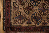 Detail of the aubergine pawn design border and low, hand-knotted pile on a vintage Belouch rug.