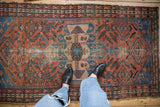 Vintage Malayer rug, dusty brick red field with Herati design, aqua spandrels, visible wear and tatter.
