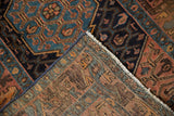 Worn geometric pile and hand-knotted foundation of a vintage Hamadan rug, with fringe.