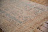 Hand-knotted Oushak carpet's even wear showing muted slate blue and blush patterns.