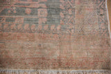 Distressed Oushak rug corner detail, highlighting even wear, muted colors, intact fringe, and selvage.