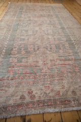 Distressed vintage Oushak rug pile with even wear, featuring blush and slate blue motifs.