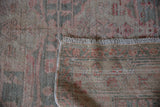 Distressed vintage Oushak carpet pile with worn texture, muted hues, and reverse foundation.