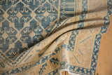 Distressed texture and denim blue geometric trellis on folded vintage Malayer rug.