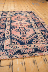 Distressed blush and navy quatrefoil medallions with hook-latch patterns on a Melas rug.