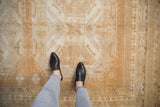 Distressed Oushak rug's starburst pinwheel motif, faded copper gold and platinum texture.
