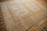 Distressed Oushak carpet border with geometric hook and latch pattern and faded neutral tones.