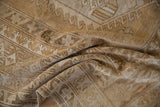 Textured distressed pile of vintage Oushak carpet in sand, beige, and faded gold.